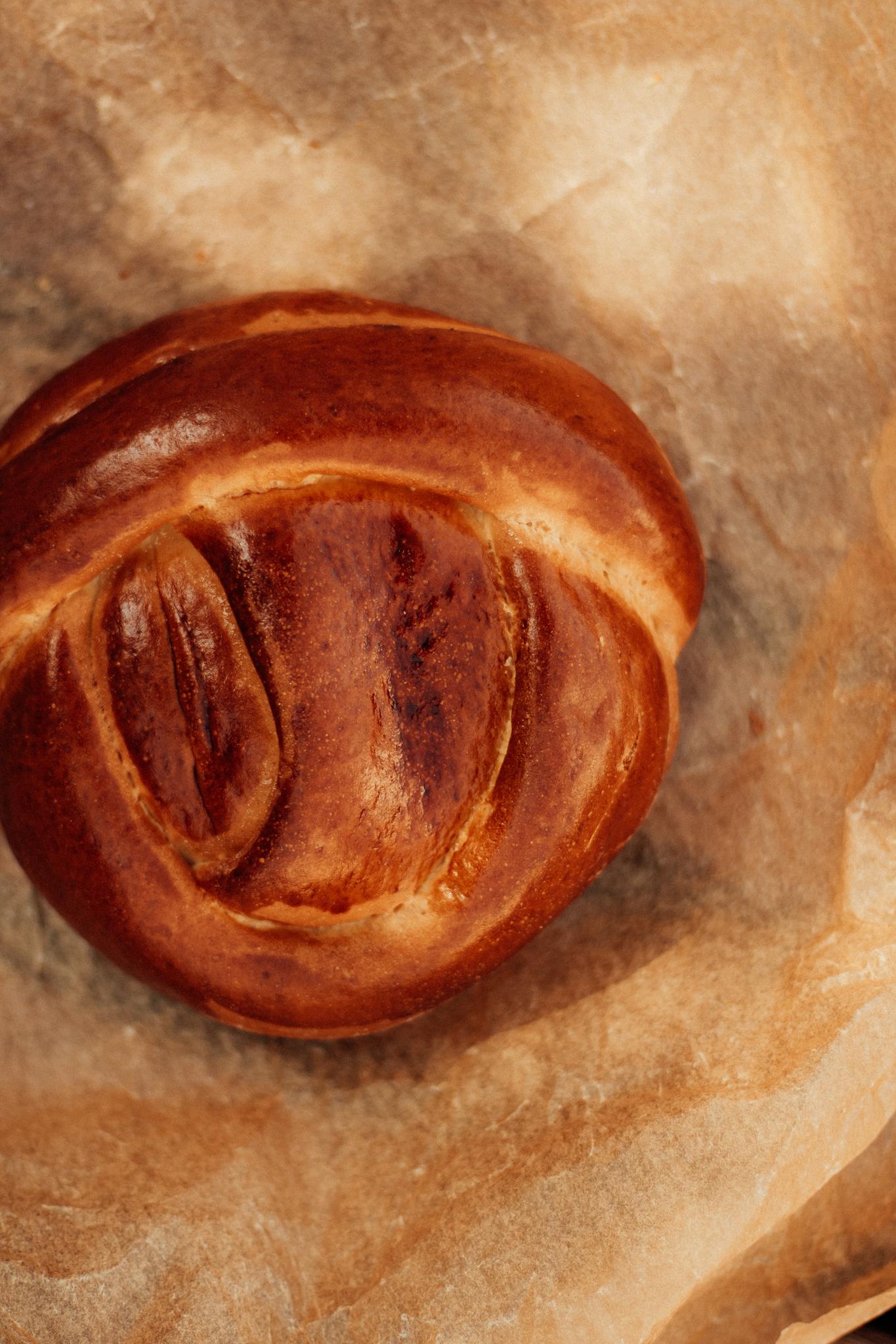 A beautifully baked sweet pastry with a golden crust, set on parchment paper, highlighting its artisanal texture.