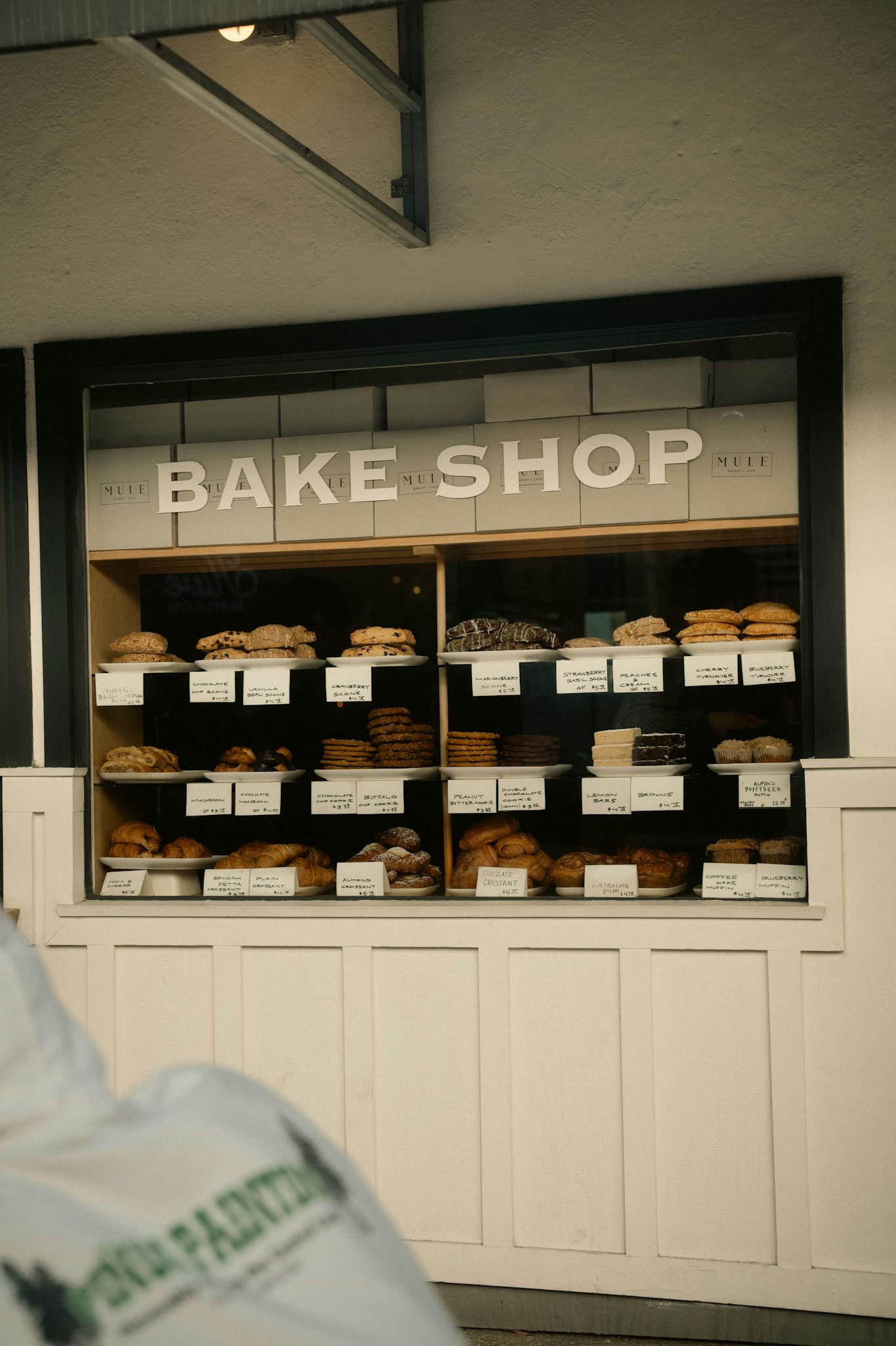 A cozy bakery shop window showcasing a variety of fresh bread and pastries.