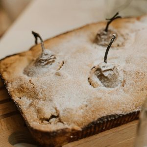 A homemade pear cake dusted with powdered sugar, perfect for dessert lovers.