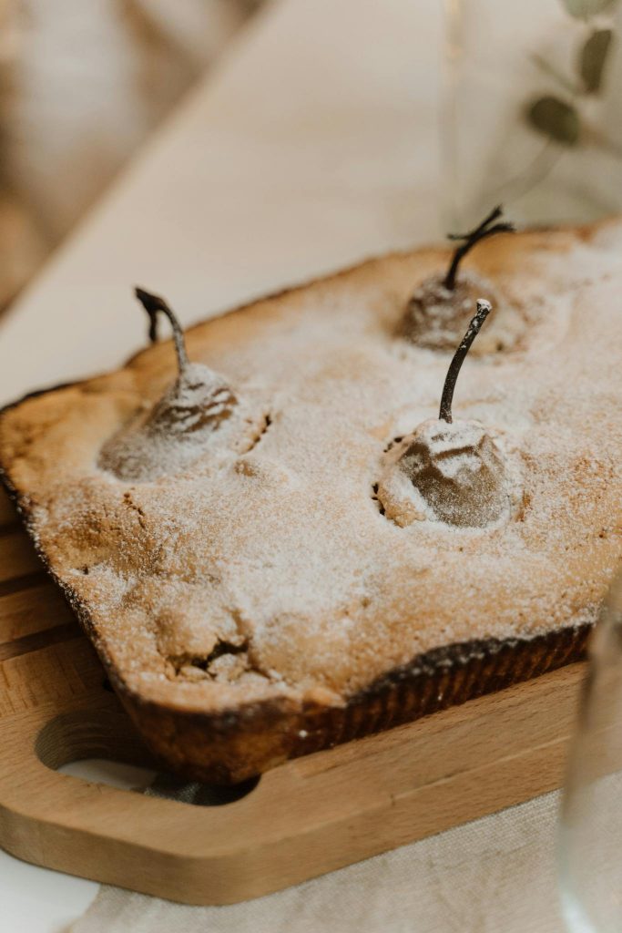 A homemade pear cake dusted with powdered sugar, perfect for dessert lovers.