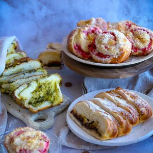 A variety of fresh pastries and bread including fruit and pesto flavoured options.