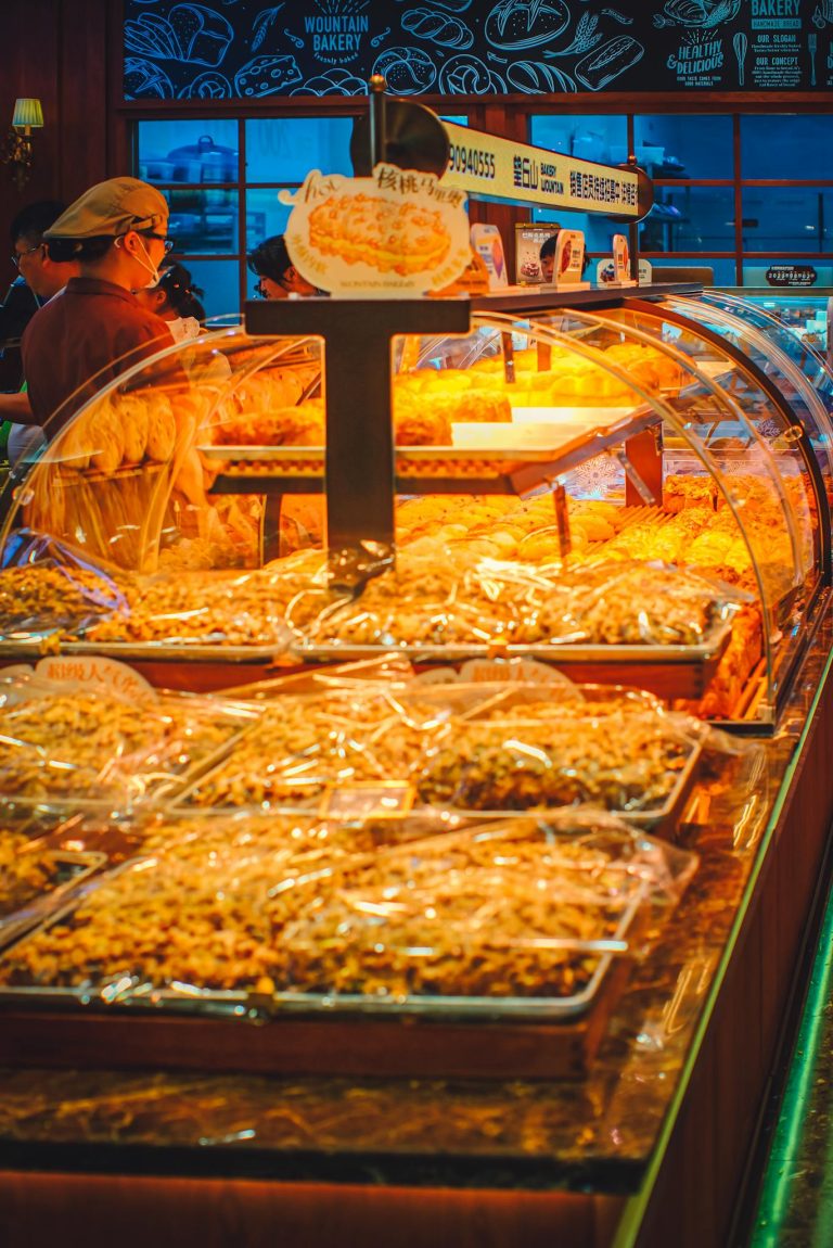 A warm bakery ambiance showcasing fresh pastries and breads under bright lighting.