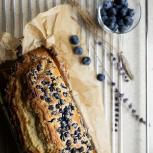 Delicious homemade blueberry cake with fresh berries on parchment paper.