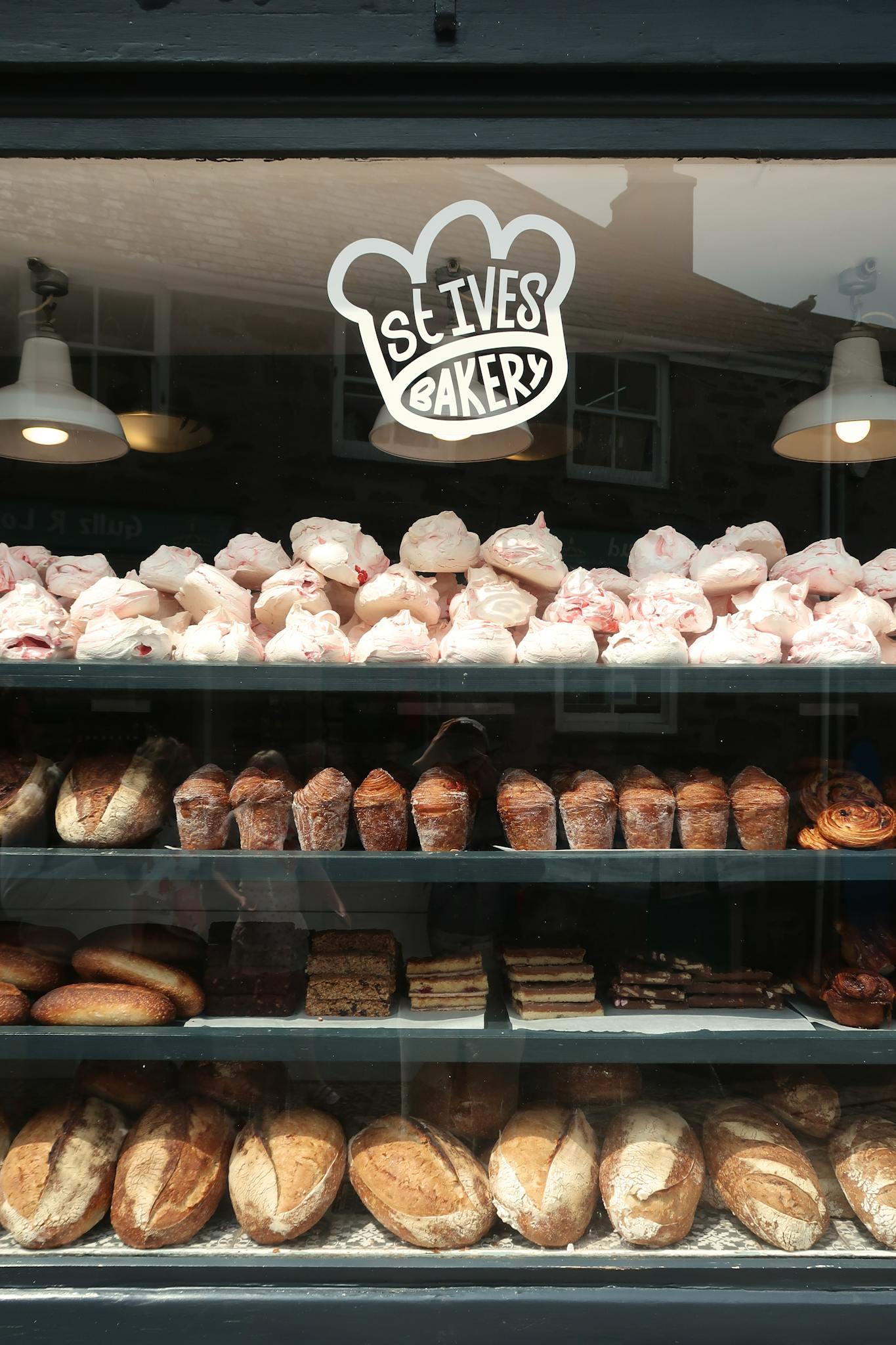 Explore the delightful display of baked goods at St Ives Bakery with fresh loaves and pastries.